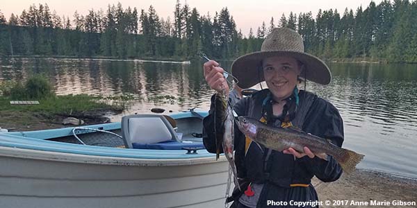 Web designer Anne Marie Gibson of Wild Song Design holding a 19" rainbow trout next to Sandy Shore Lake. Photo Copyright ©2017 Anne Marie Gibson / Wild Song Design. All Rights Reserved. Licensed to North Hood Canal Chamber of Commerce for use on emeraldtowns.com.